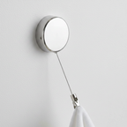 Close-up of the polished stainless steel adhesive retractable towel holder and clip