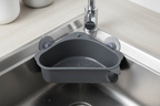 Close-up of triangular dark gray sink strainer basket with perforated base and suction cups